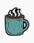 Enamel pin of a teal mug with steam on a white background