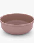 A dusty rose rolled enamel bowl on a white background