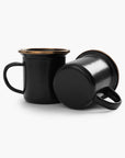 Two 5 oz black enamel espresso cups with copper plated rims on a white background.