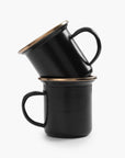 Two stacked 5 oz black enamel espresso cups with copper plated rims on a white background.