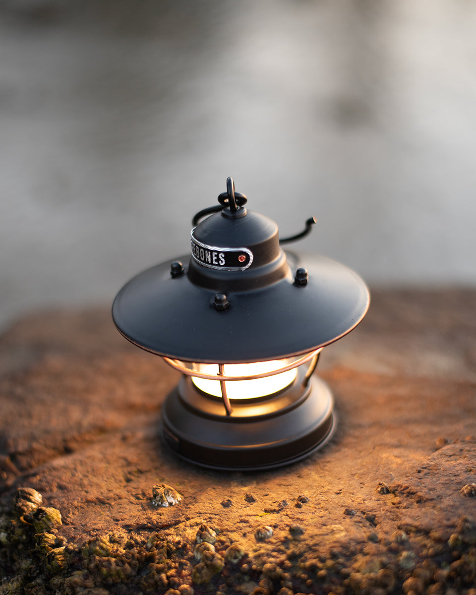 Edison mini lantern with a warm glow on a textured surface